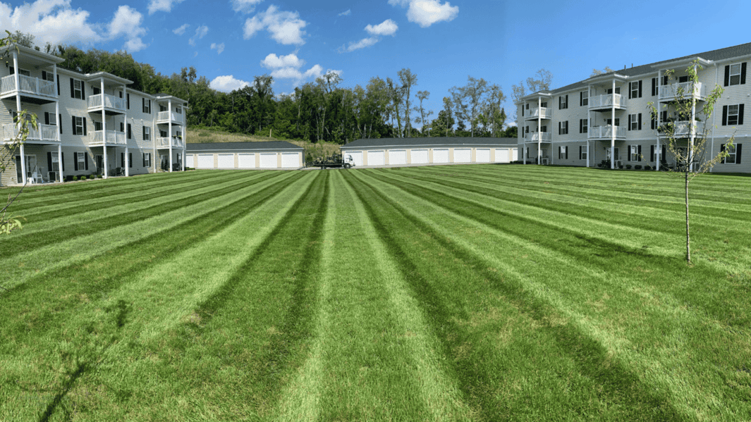 Professional commercial lawn mowing by TruScape, showcasing clean, uniform striping at an apartment complex in Greensburg, PA